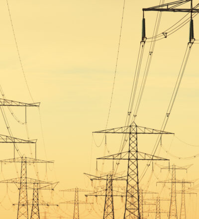 Powerline electricity towers in a row during a colorful sunset.